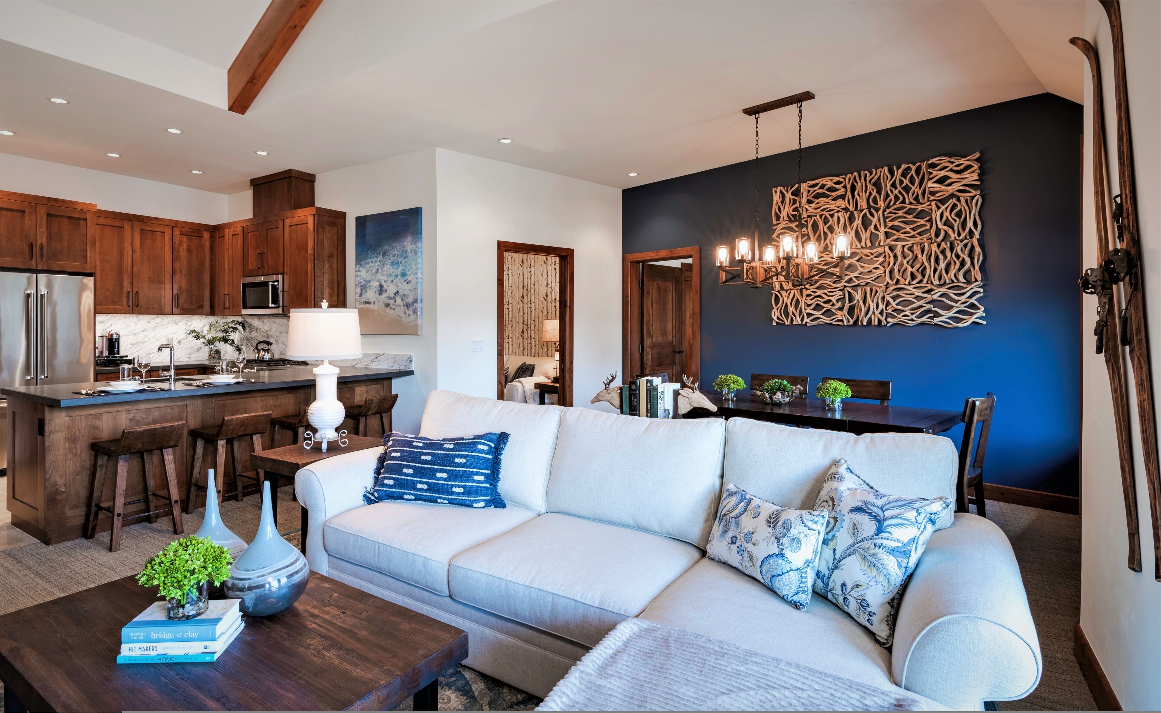 A modern living room with a sofa, coffee table, and a dining area with a table and chairs.