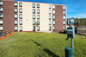 A hotel building with multiple windows and a sign indicating a dog waste station.