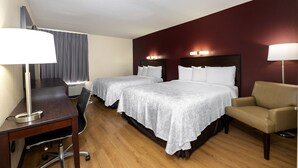 A hotel room with two beds, a desk, a chair, and a desk lamp. - Red Roof Inn PLUS+ Tuscaloosa - University (Tuscaloosa)