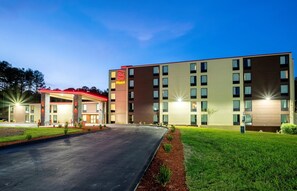 A multi-story hotel with a flat roof, a parking lot, and a well-maintained lawn. - Red Roof Inn PLUS+ Tuscaloosa - University (Tuscaloosa)