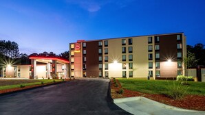 A multi-story hotel with a red awning and a well-lit entrance. - Red Roof Inn PLUS+ Tuscaloosa - University (Tuscaloosa)