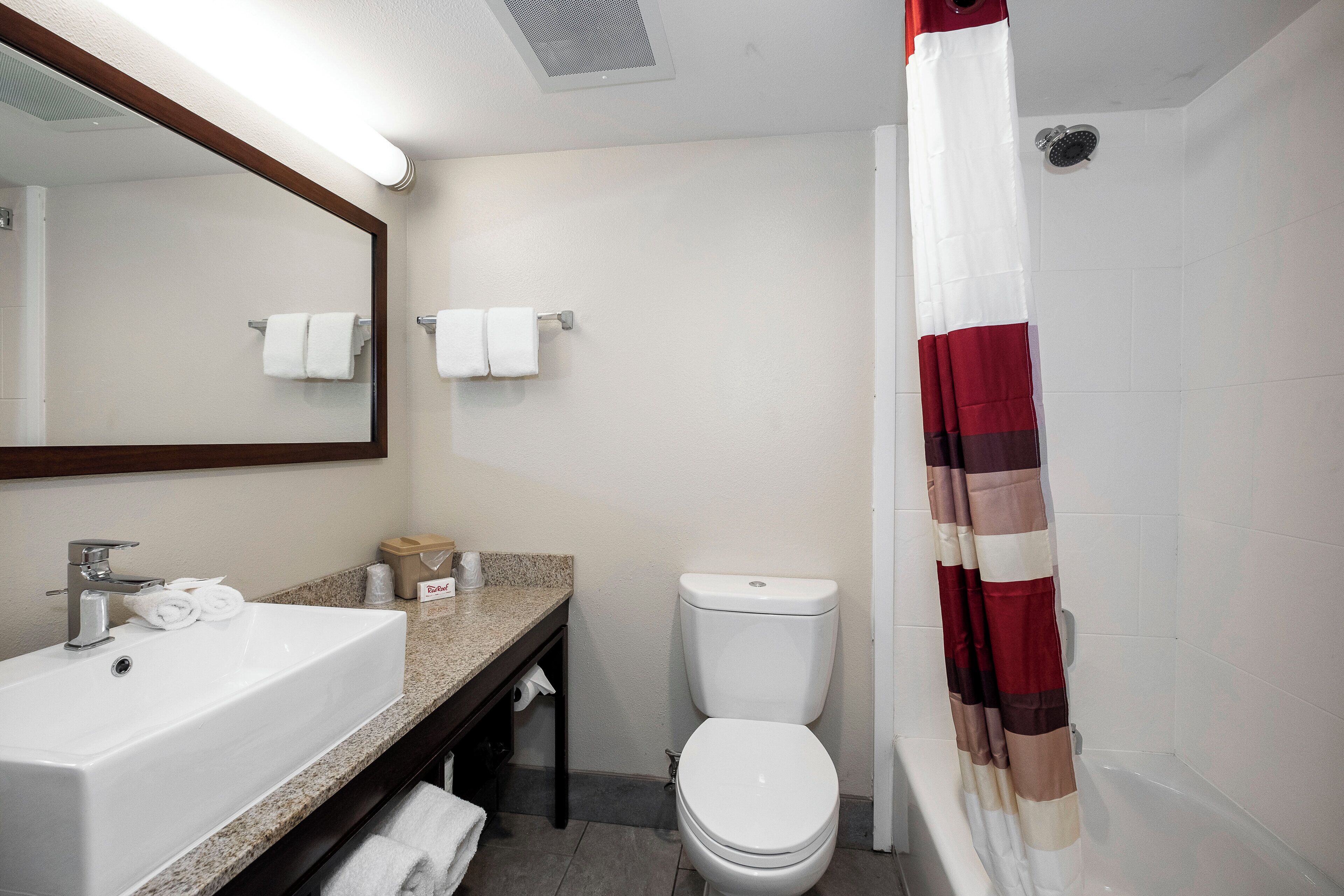 A bathroom with a sink, toilet, and shower curtain.