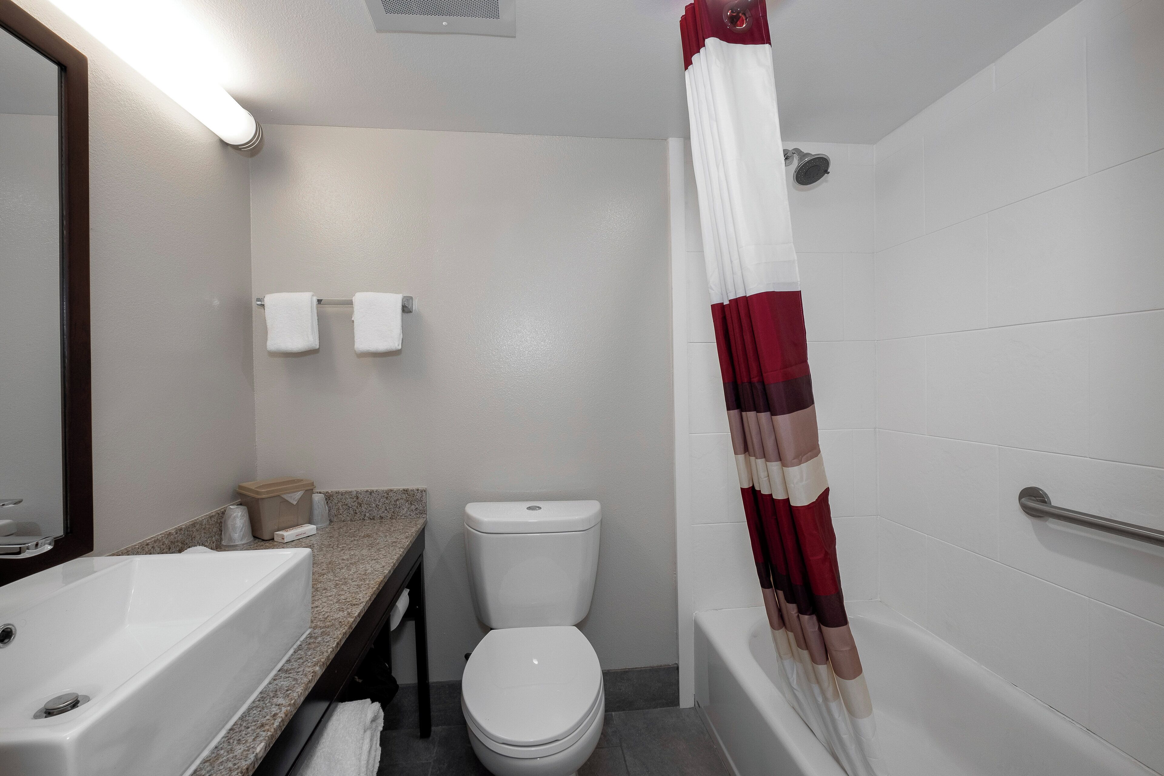 A bathroom with a bathtub, toilet, and sink.