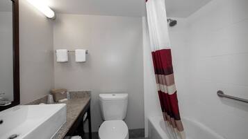 A bathroom with a bathtub, toilet, and sink.