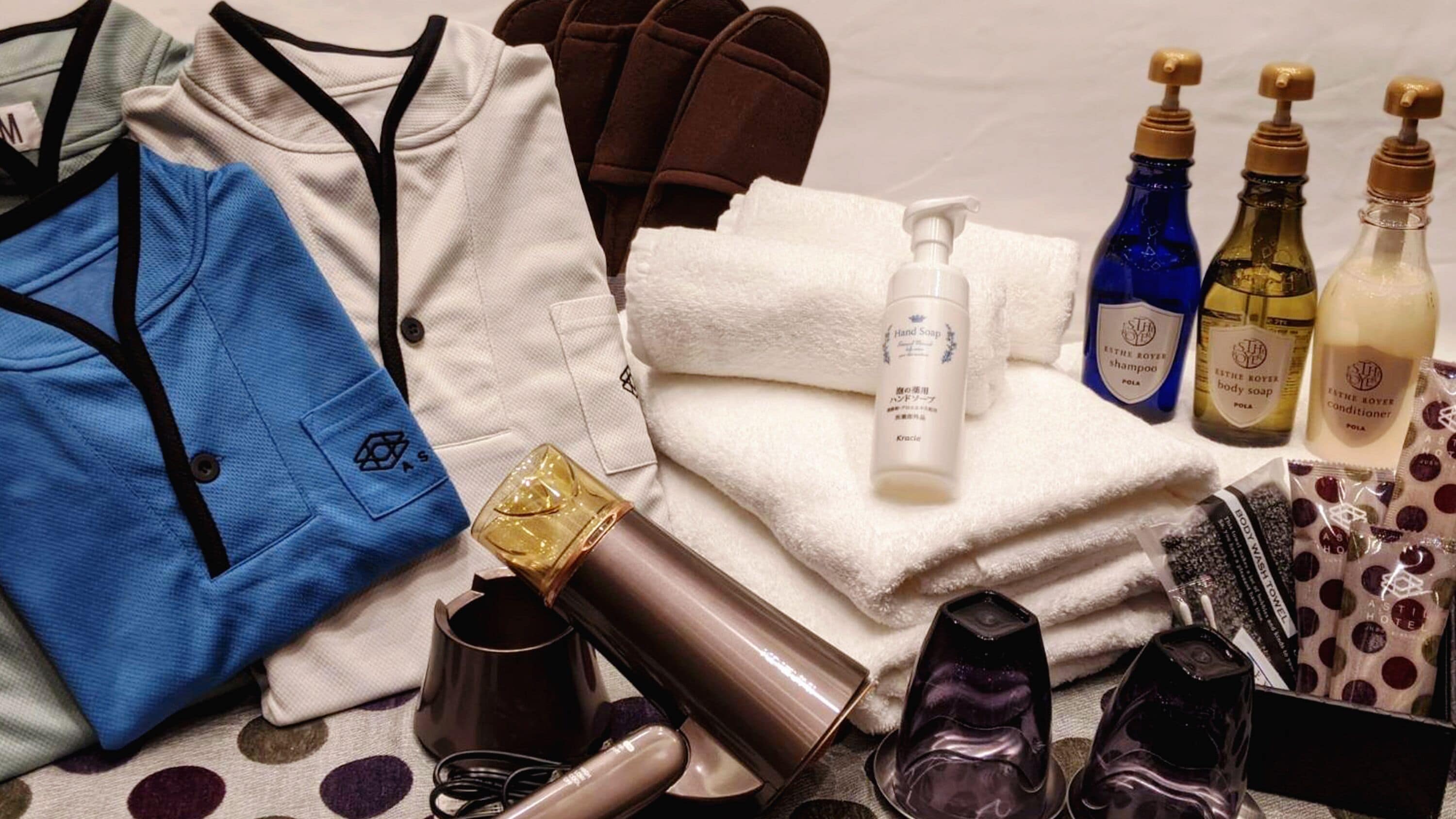 Een netjes gerangschikte verzameling toiletartikelen, waaronder handzeep, shampoo, douchegel en conditioner.