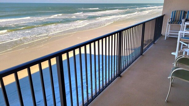 Un balcon avec vue sur la plage et l’océan.