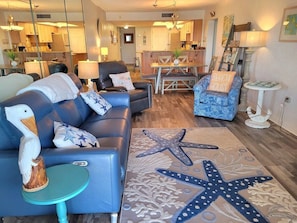 A modern living room with a sofa, armchair, and a starfish rug.