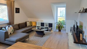 A modern living room with a sectional sofa, a coffee table, and a TV stand.