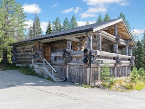 A rustic log cabin with a porch, a staircase leading to the entrance, and a clear sky in the background. - Kitka-nokkela by Interhome (Kuusamo)