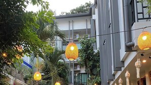A courtyard with a dining area, outdoor furniture, and hanging lanterns. - The Locals Chiang Mai (Chiang Mai)