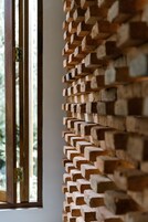 A wall of stacked bricks with a window to the left.