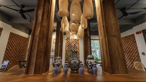 A room with wooden pillars, hanging woven light fixtures, and a table with blue and white patterned vases. - The Locals Chiang Mai (Chiang Mai)