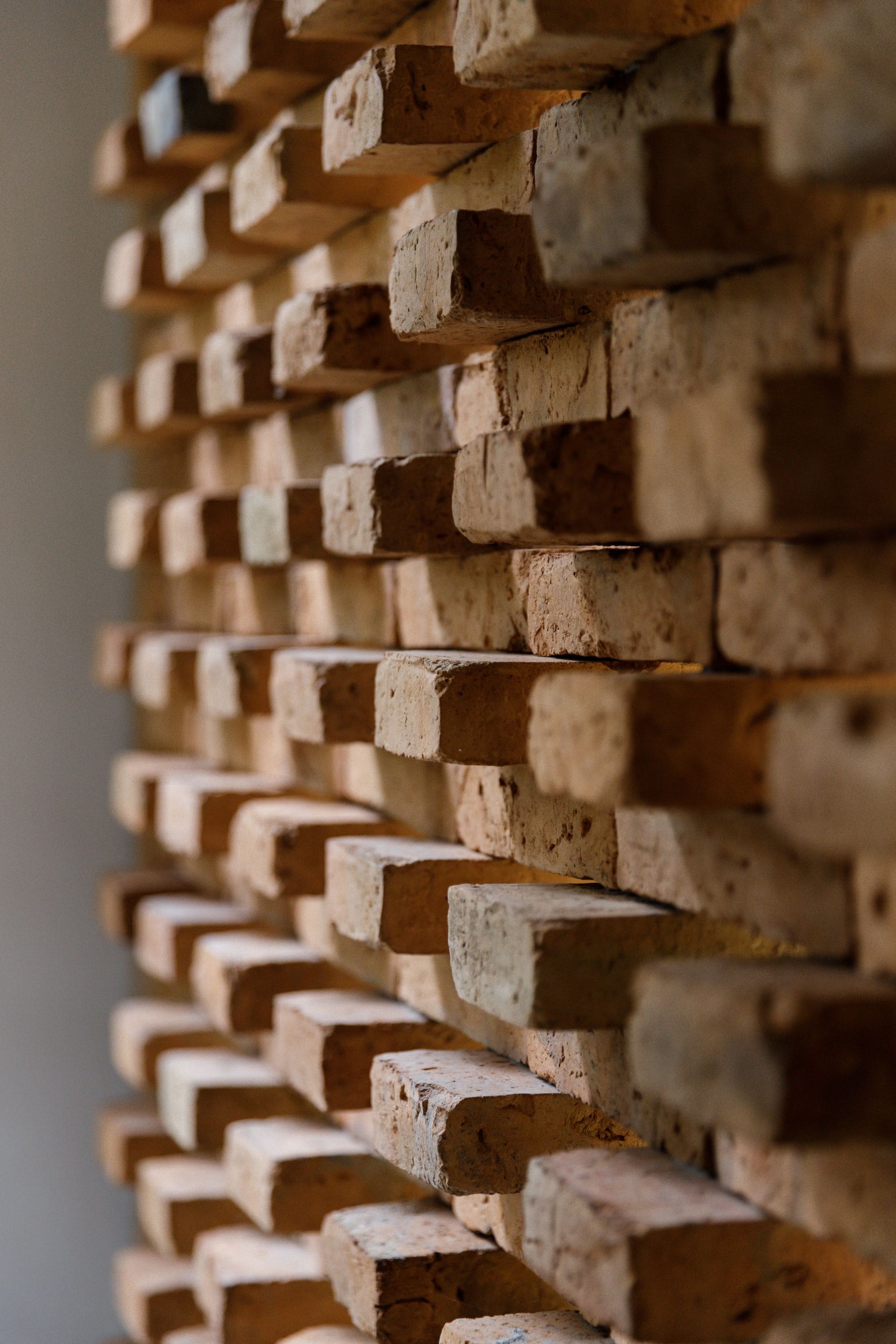 A stack of uniformly shaped, rectangular bricks arranged in a repeating pattern.