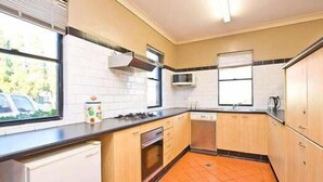 Una cocina compacta con estufa a gas, microondas y lavavajillas.
