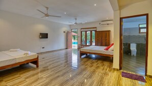 A spacious room with two beds, a ceiling fan, and a TV. - Om Residence (Beruwela)