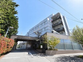 Un edificio moderno con un cartel que dice 'hotel estilo años 50' y un área de estacionamiento al frente.