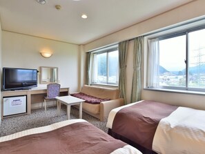 A hotel room with two beds, a TV, a desk, a chair, and a window with curtains. - Chino Sky View Hotel (Chino)