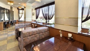 A restaurant with booth seating, a bar area, and large windows with curtains. - Chino Sky View Hotel (Chino)