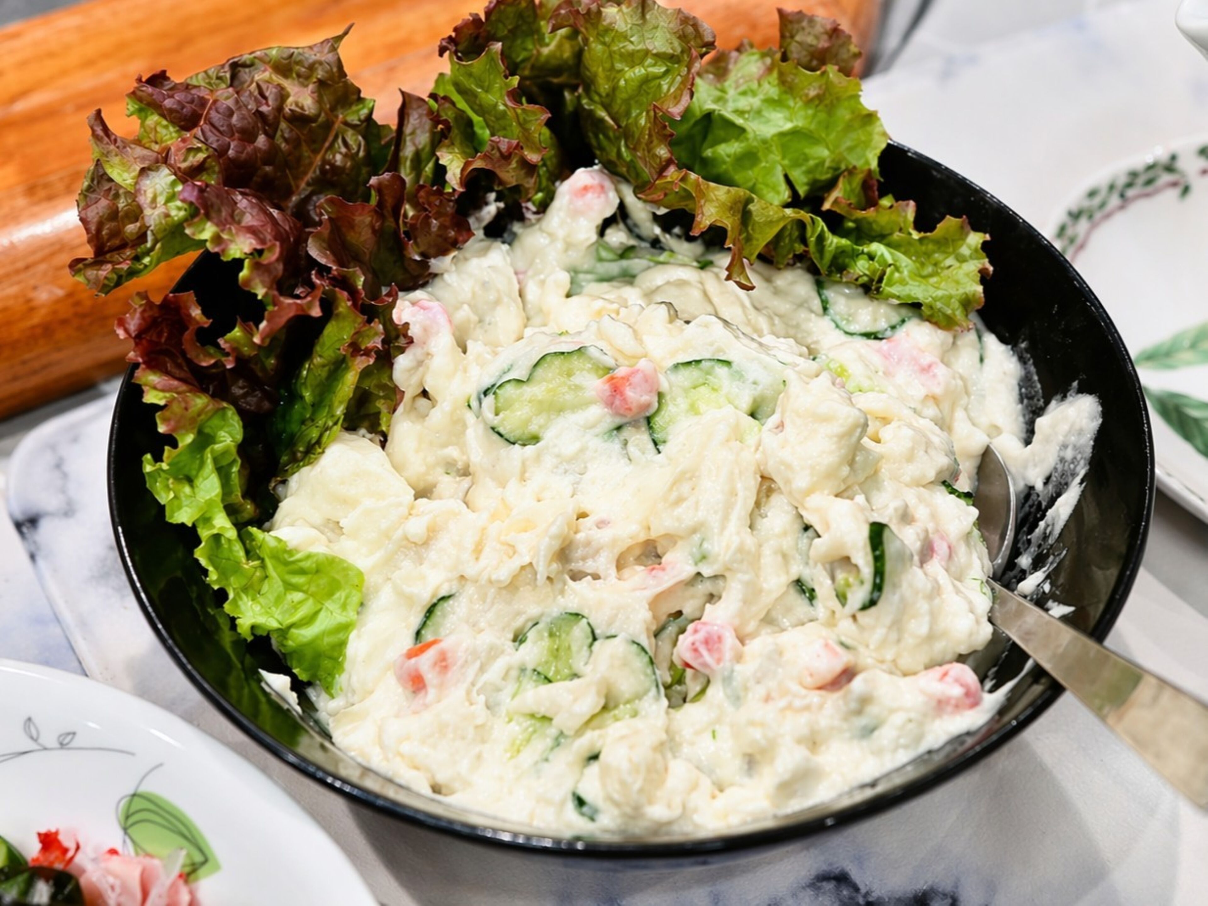 Un tazón de ensalada con lechuga y pepino.