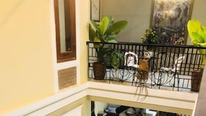 A multi-level interior with a staircase connecting floors, potted plants, and a scooter. - Hoi An Lake Shore Homestay (Da Nang)