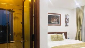 A hotel room with a bed, a painting on the wall, and a shower area. - Hoi An Lake Shore Homestay (Da Nang)