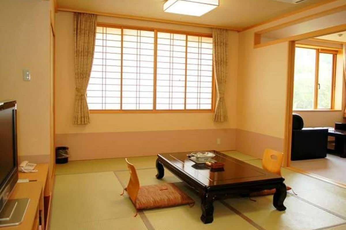 A traditional Japanese room with tatami flooring, a low table, and sliding doors.