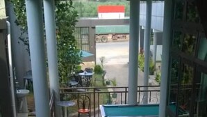 Une table de billard dans une pièce avec un balcon donnant sur une rue.