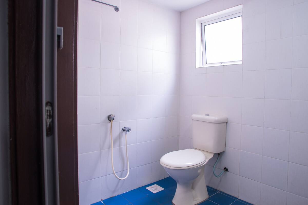 Un baño pequeño con inodoro, ducha y ventana.