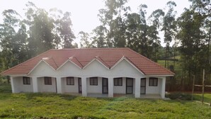 A single-story building with a red-tiled roof and white walls, surrounded by green grass and trees. - Sky Resort (Kitagata)