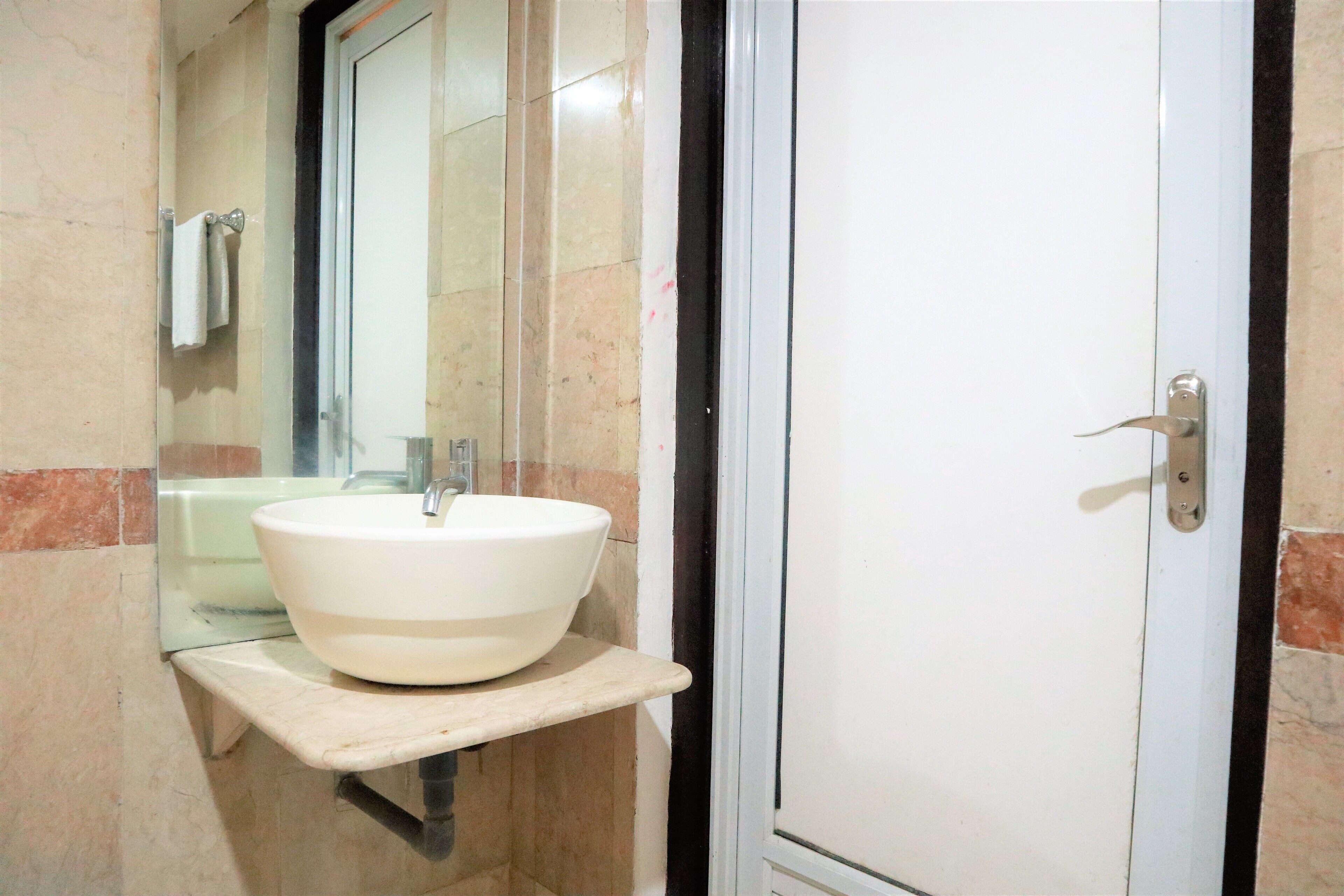 A bathroom with a white sink, a mirror, and a door.