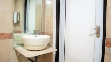 A bathroom with a white sink, a mirror, and a door.