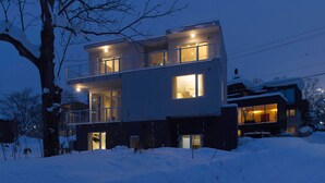A modern two-story house with a balcony, surrounded by snow. - Mizunara Chalet (Kutchan)