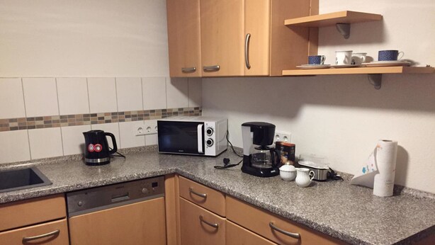A compact kitchen with a microwave, coffee maker, and a sink. - Pfaffenhofen Monteurzimmer (Pfaffenhofen)