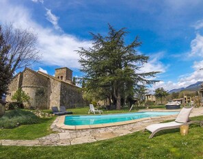 A stone building with a tower, a swimming pool, and lounge chairs. - Tiny house with jacuzzi - Rectoria de Dosquers (Maia De Montcal)