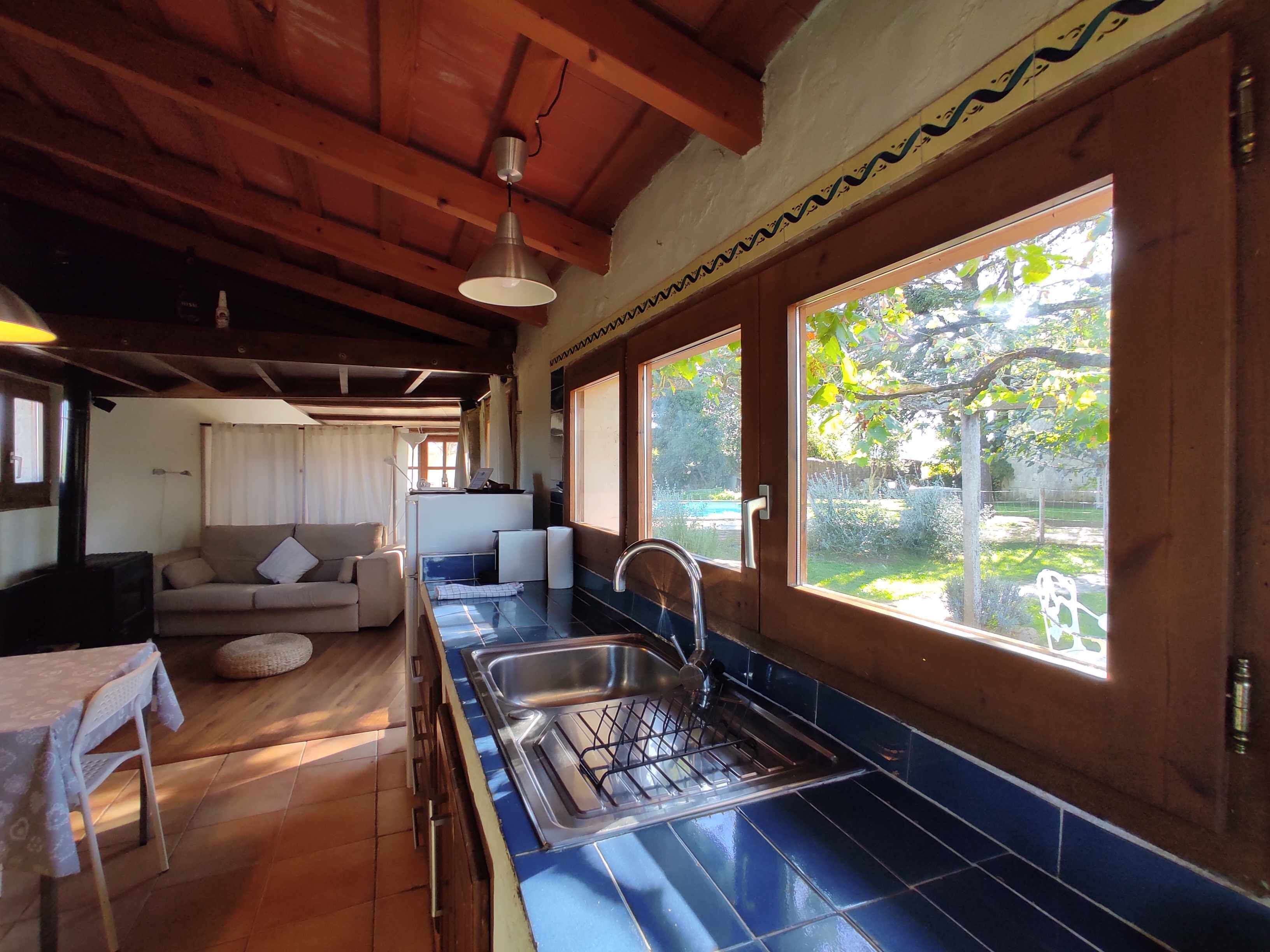 Una cocina compacta con lavamanos, estufa y comedor con mesa y sillas.