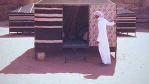 A traditional tent-like structure with a flat roof, a bench, and a pot outside. - Bedouin Experience Camp (Wadi Rum)
