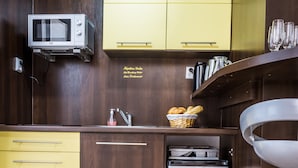 A compact kitchen with wooden cabinetry, a microwave, a mini-fridge, and a sink. - Apartment Eric 9D High Tatras (Velky Slavkov)