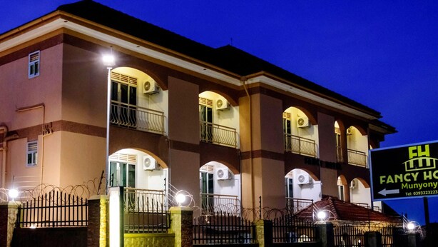 A hotel with multiple balconies, a signboard, and a well-lit entrance. - Fancy Hotel (Kampala)