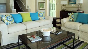 Ein Wohnzimmer mit einem weißen Sofa, einem Couchtisch und einem gemusterten Teppich.