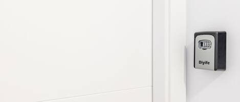 A white door with a metal Y-shaped handle, a metal keyhole, and a Djiife electronic lock.