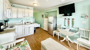 A compact kitchen with white cabinets, a refrigerator, and a ceiling fan. - Beachfront Community • Private Beach Access • Pool • WiFi • Kitchen (Atlantic Beach)