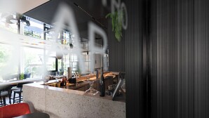 A modern kitchen with a large island, bar stools, and a seating area with a view of the outdoors. - Das Altmühltal (Eichstaett)