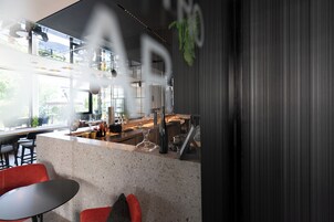 Una cocina moderna con una isla grande, taburetes de bar y una zona de estar con vistas al exterior.