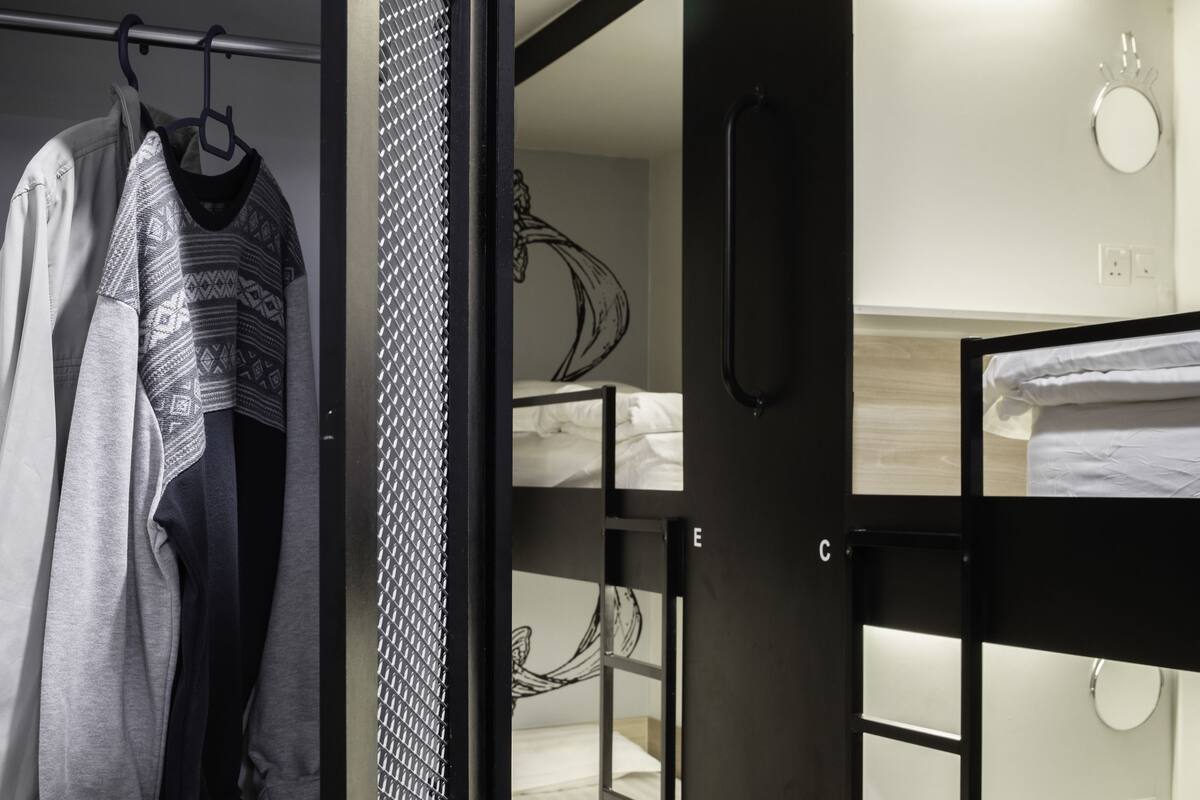 A bunk bed room with a wardrobe and a mirror.