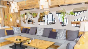 A modern living room with a grey sofa, two wooden coffee tables, and mirrors on the walls. - Hotel Mei Fukuoka Tenjin (Fukuoka)