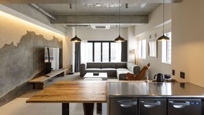 A modern kitchen with a wooden table, stainless steel appliances, and a built-in oven. - Hotel Mei Fukuoka Tenjin (Fukuoka)