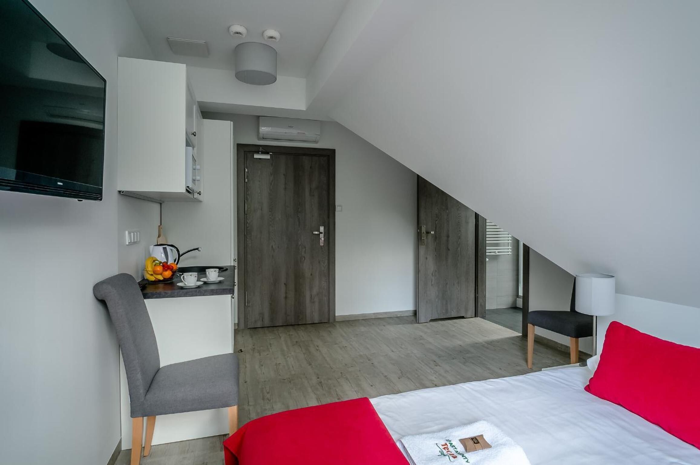 Una habitación de hotel moderna con cama, escritorio y kitchenette.