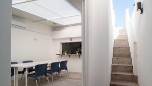 A modern interior with a dining area, a kitchen counter, and a staircase. - Elba Suites Gaia-Porto (Vila Nova de Gaia)