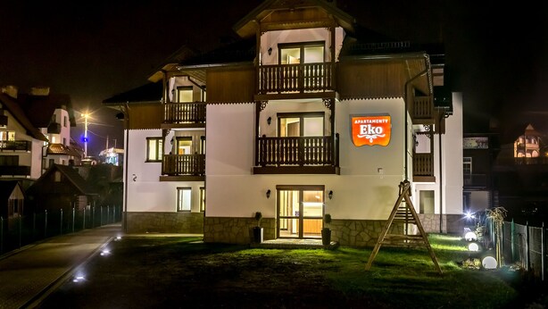 A two-story building with a sign reading "APARTMENTY Eko".