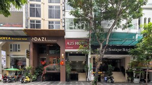 Un immeuble à plusieurs étages comprenant un hôtel-boutique, un hôtel de luxe et un hôtel doté d’un auvent vert.
